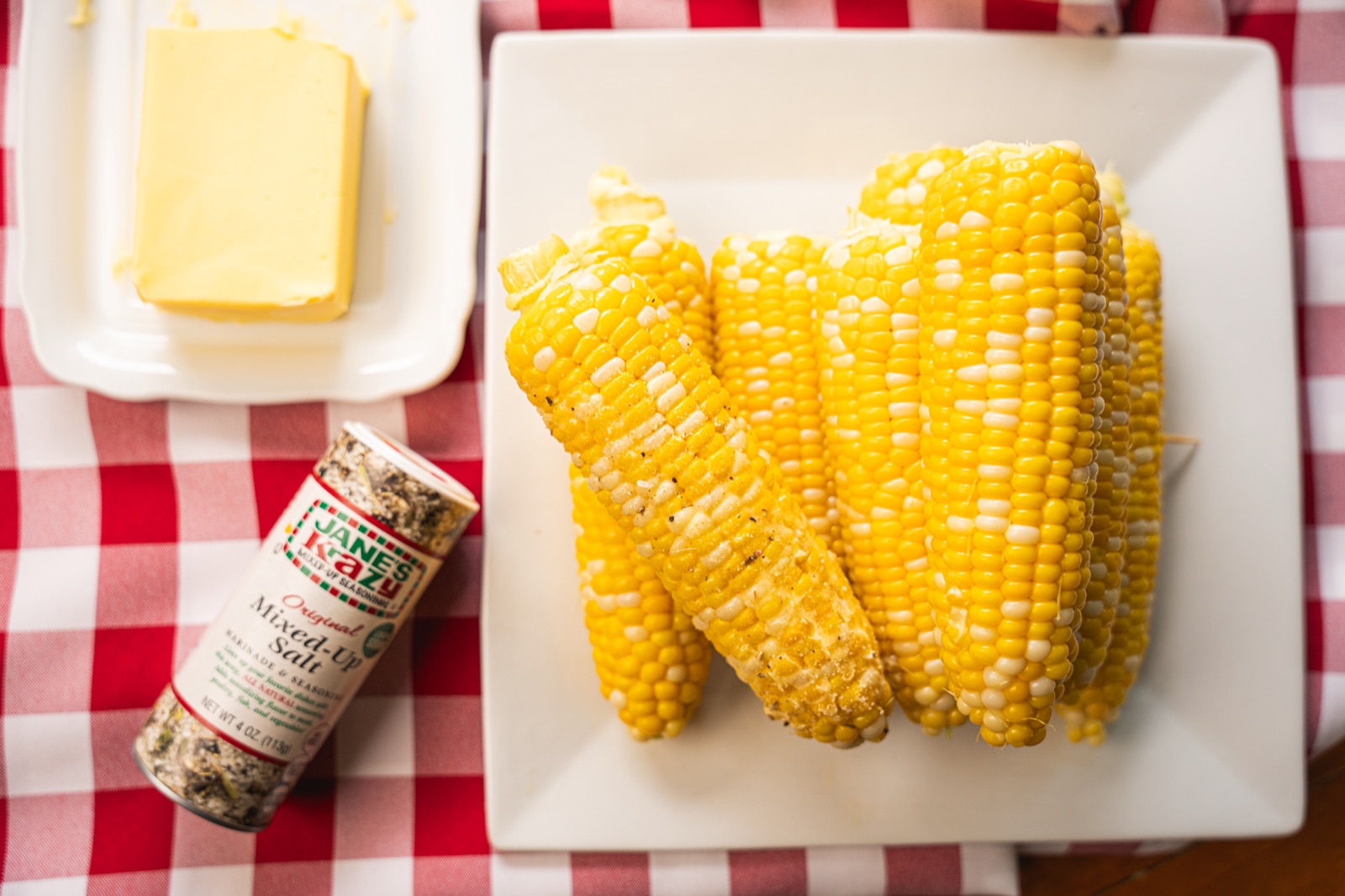 Seasoned corn on the cob topped with a pat of butter.
