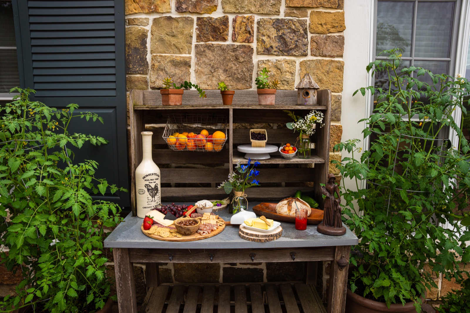 A farmstand display of tomatoes and produce in a garden.