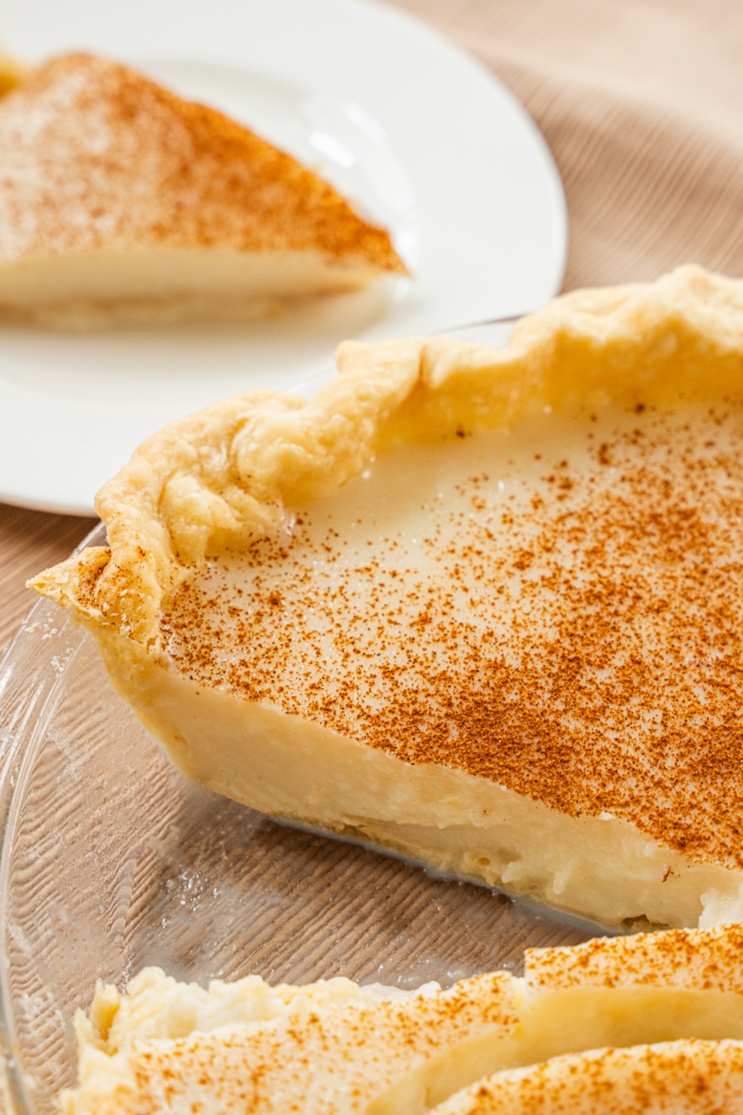 Close-up of a custard pie dusted with cinnamon.